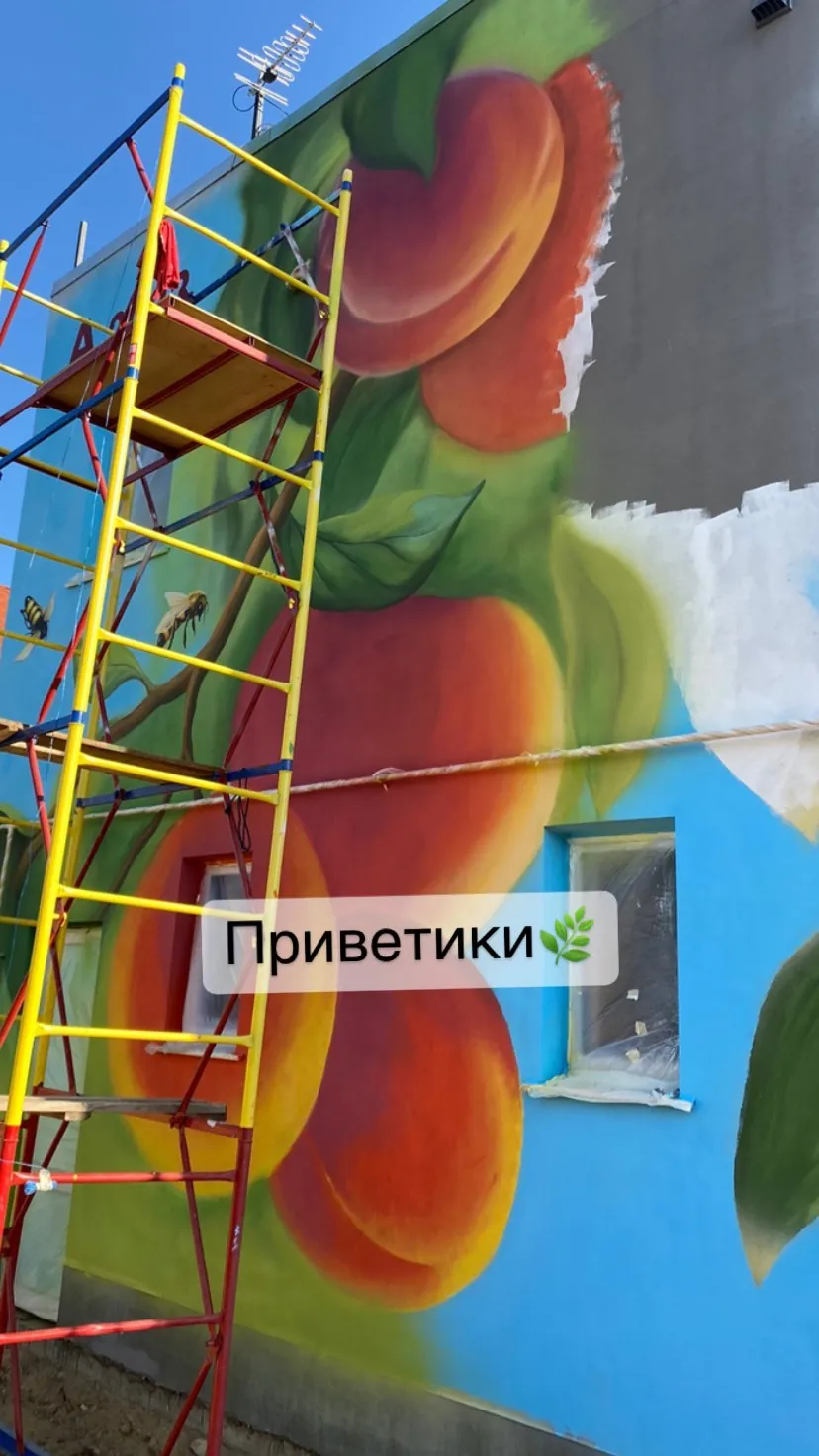Спелые персики на фасаде здания